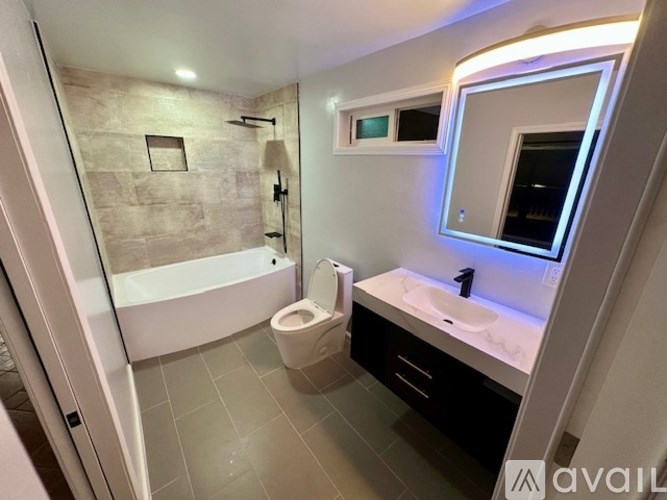 A bathroom with a toilet, sink, and bathtub.