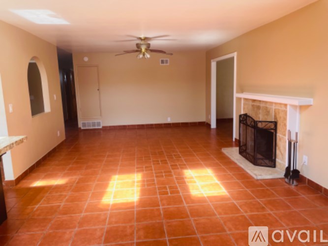 A room with a fireplace and a ceiling fan.