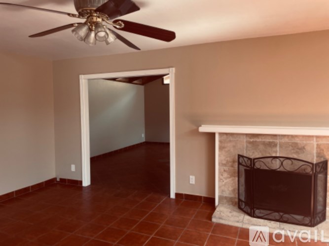 A room with a fireplace and a ceiling fan.