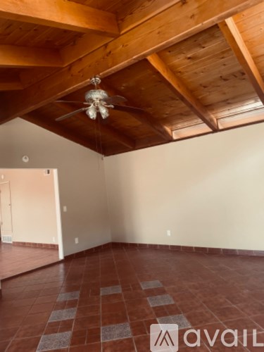 A room with a wooden ceiling and a fan.