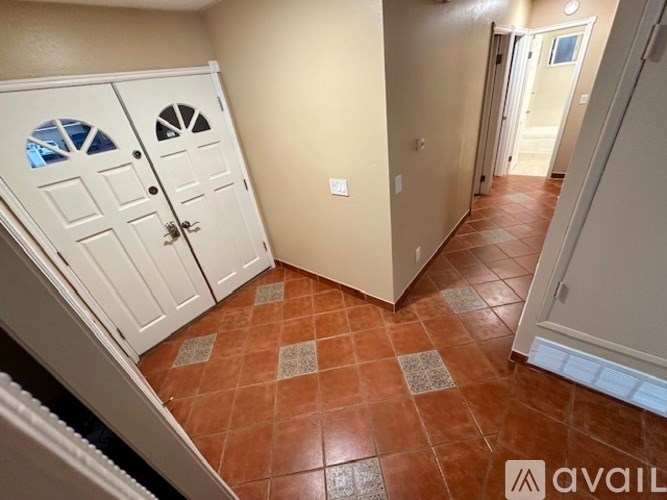 A white closet with shelves and a wooden door.