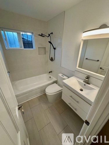 A bathroom with a white tub, sink, and toilet.