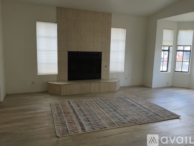 A living room with a television and a rug.