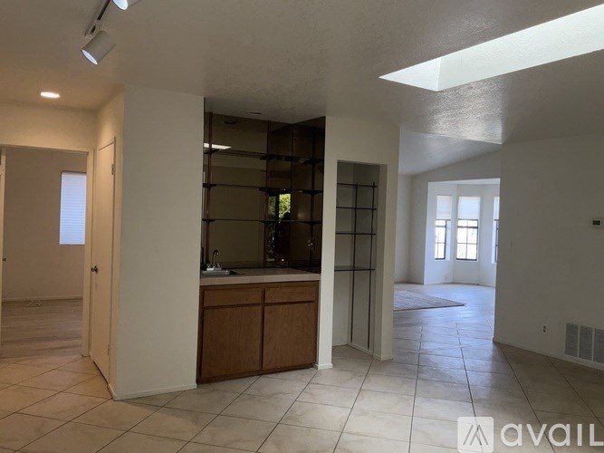 A spacious room with a kitchen area and a large window.