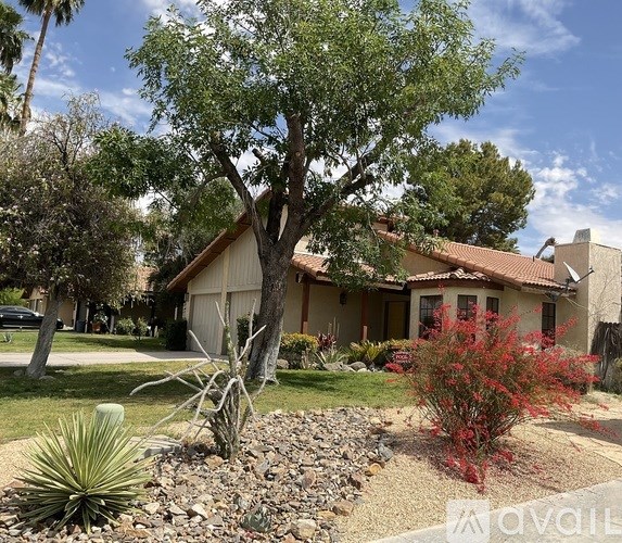 A house with a red roof and a tree in front of it.