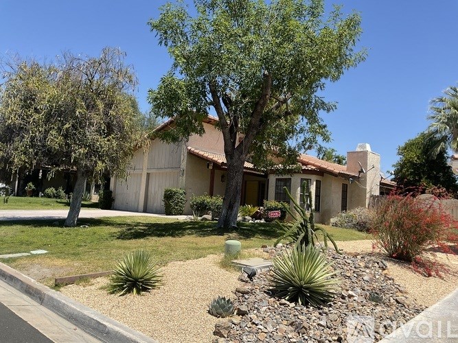 A house with a brown roof and a garden in front.