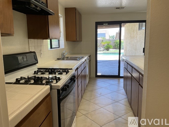 A kitchen with a black stove top oven and a white counter top.