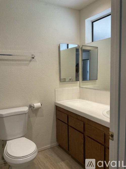 A white toilet sits next to a sink in a small bathroom.
