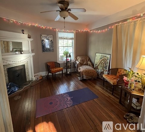 A living room with wooden floors and a fireplace.