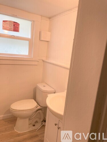 A white toilet and sink in a small bathroom.