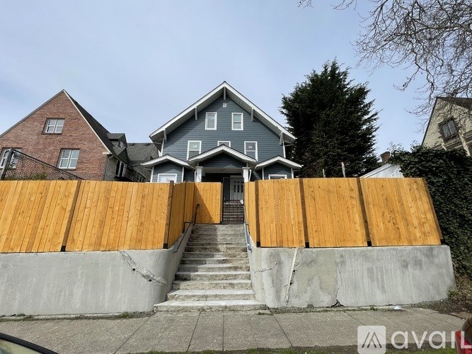 A house with a grey roof and a wooden fence in front.