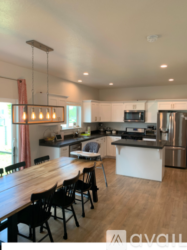 A modern kitchen with wooden chairs and a wooden table.