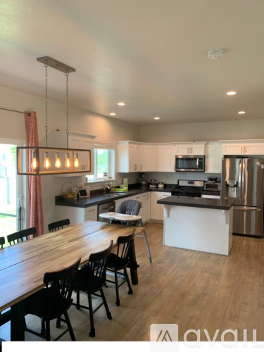 A modern kitchen with wooden chairs and a wooden table.