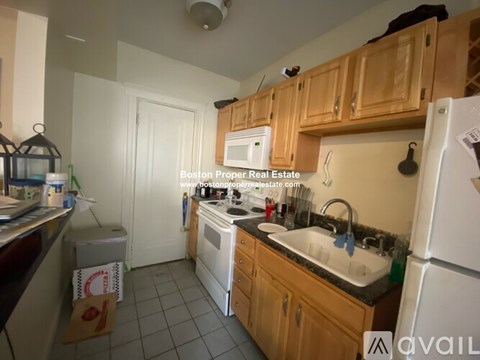 A kitchen with wooden cabinets and a white refrigerator.