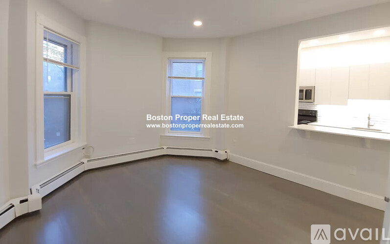 A spacious empty room with a window and a countertop.