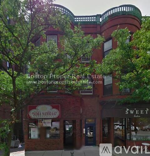 A building with a red sign that says "India Samrat" is in front of a tree.