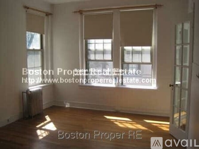 A room with wooden floors and a window letting in sunlight.