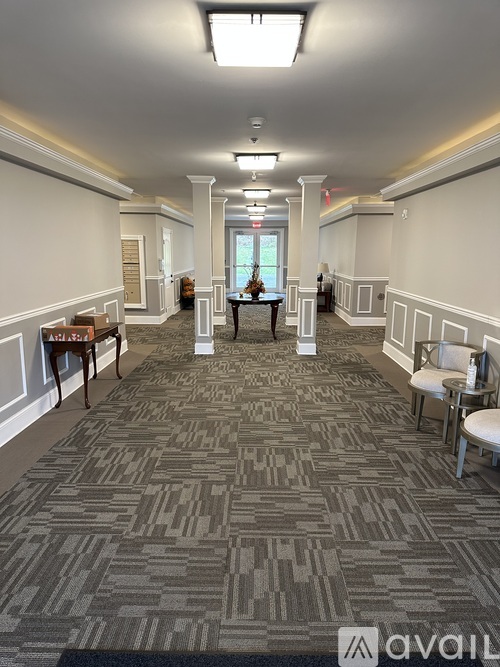 A carpeted hallway with a patterned carpet and white walls.