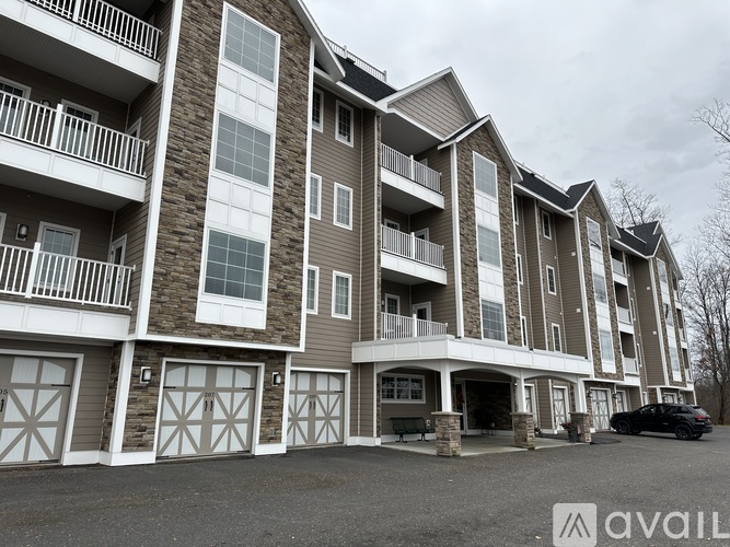 A large apartment building with multiple balconies and garage doors.