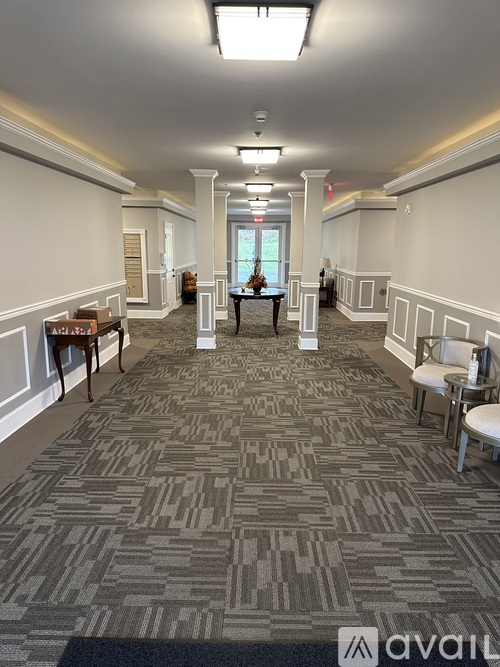 A long hallway with chairs and tables on either side.