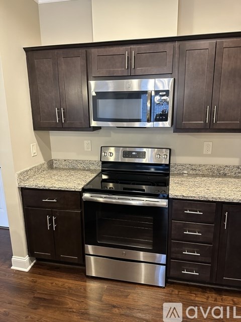 A kitchen with dark brown cabinets and stainless steel appliances.