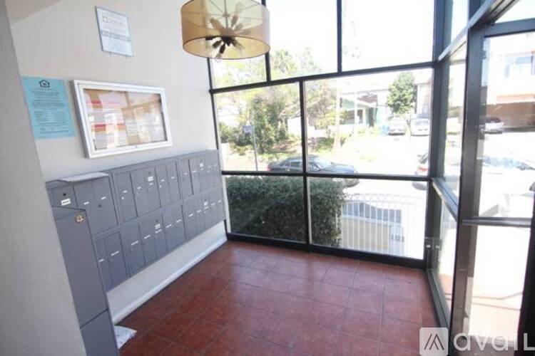 A room with a red floor and a glass wall overlooking a parking lot.