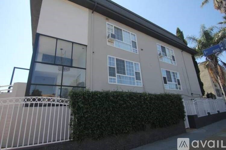 A two-story building with a balcony and a fence in front.