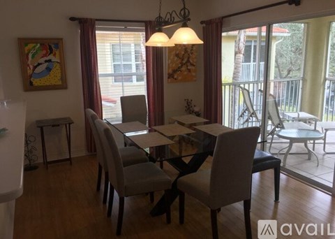 A dining room with a table and chairs.