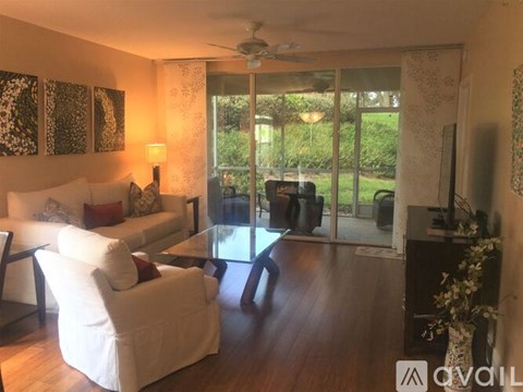 A living room with a white couch and a glass table.