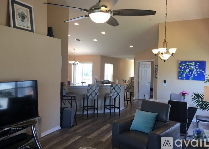 A living room with a television, a couch, and a dining table.
