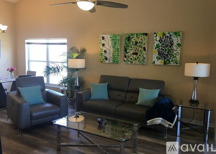 A living room with a couch, chair, and two lamps.