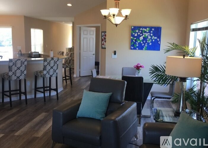 A living room with a couch, chairs, and a dining table.