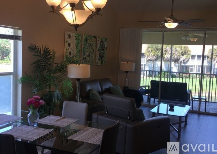 A living room with a couch, chairs, and a television.