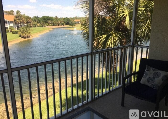 A balcony with a chair overlooking a river.