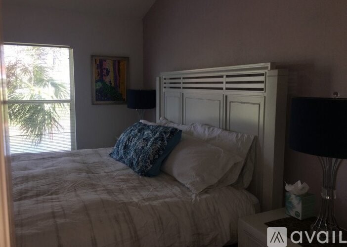 A bedroom with a bed, nightstand, and lamp.