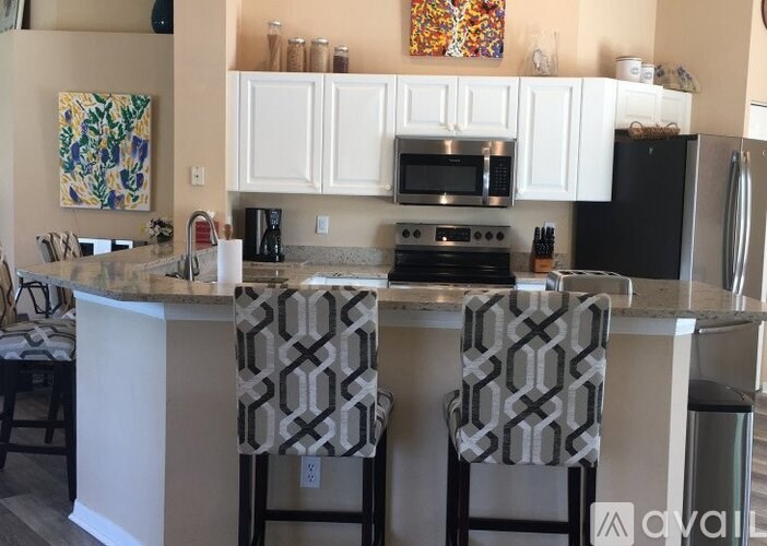 A kitchen with a granite countertop and two barstools.