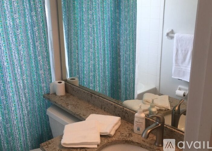 A bathroom with a toilet, sink, and a mirror.