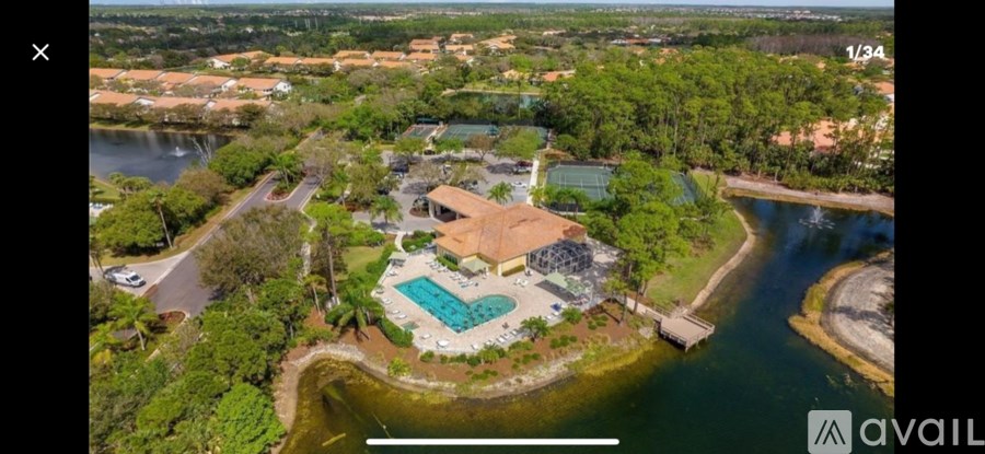 A bird's eye view of a house with a swimming pool surrounded by a forested area.