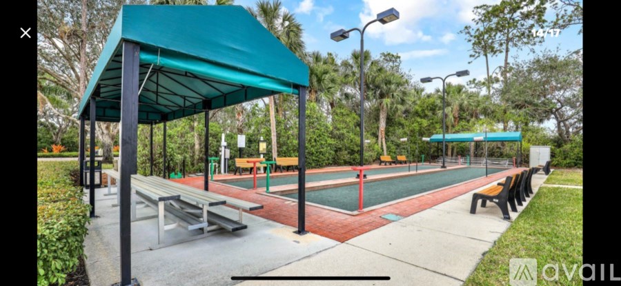 A park with a green canopy and a red track.