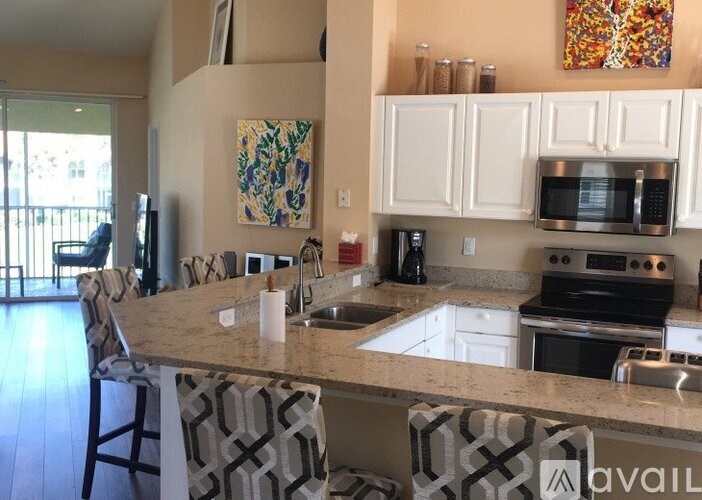 A kitchen with a granite countertop and white cabinets.