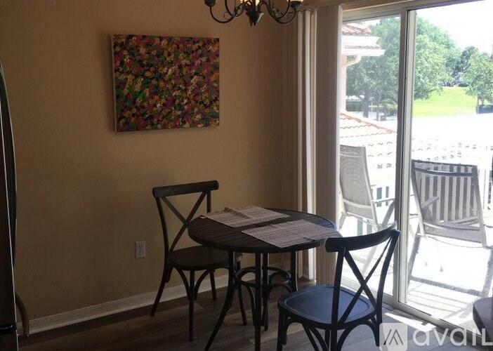 A dining table with chairs and a painting on the wall.