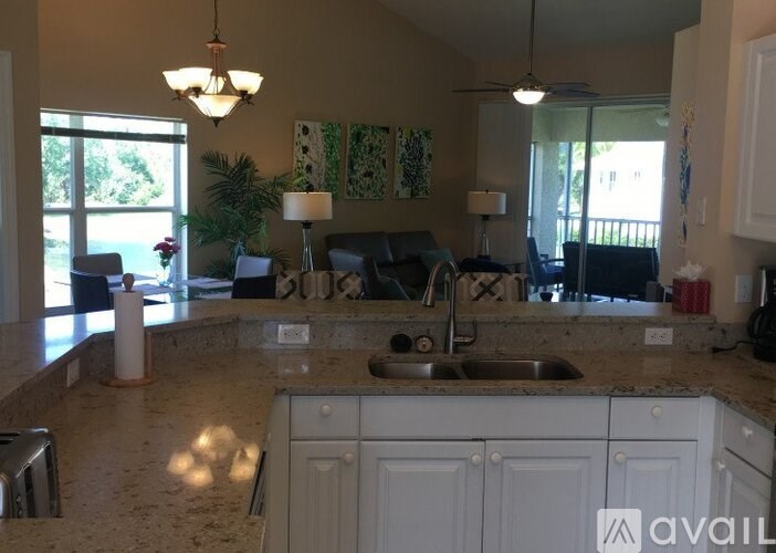 A kitchen with granite countertops and white cabinets.