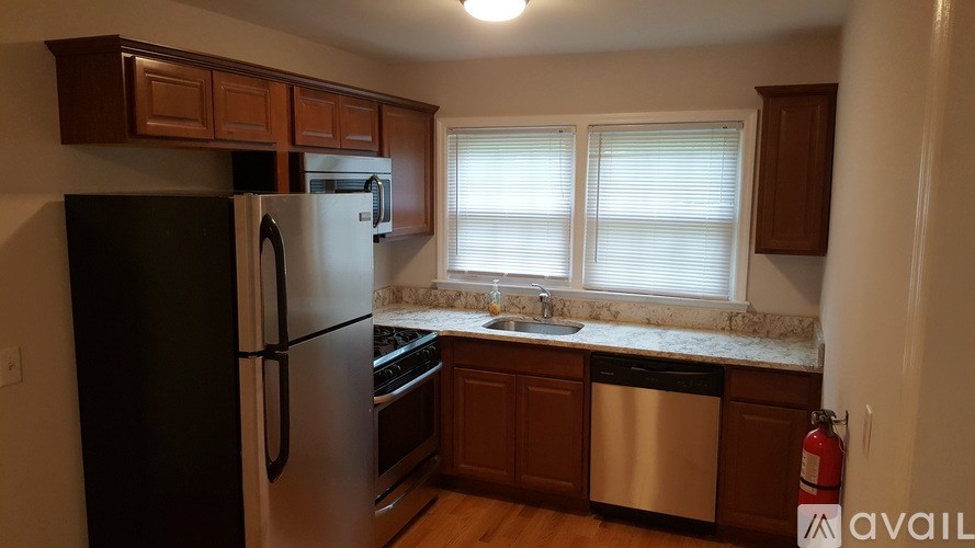 A kitchen with a black refrigerator and stainless steel dishwasher.