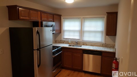 A kitchen with a black refrigerator and stainless steel dishwasher.