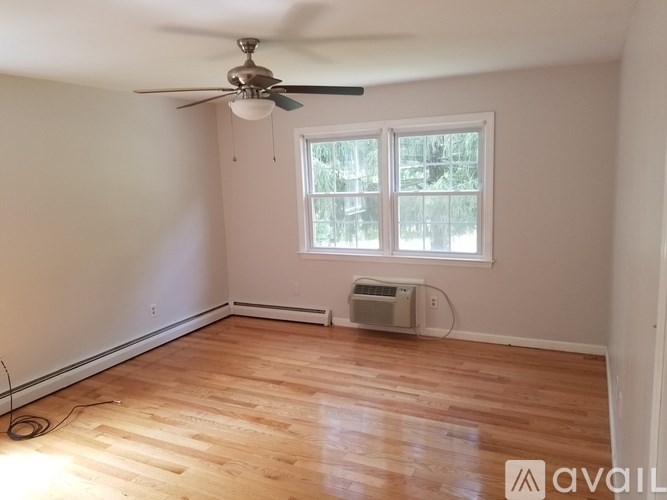 A room with wooden flooring and a ceiling fan.