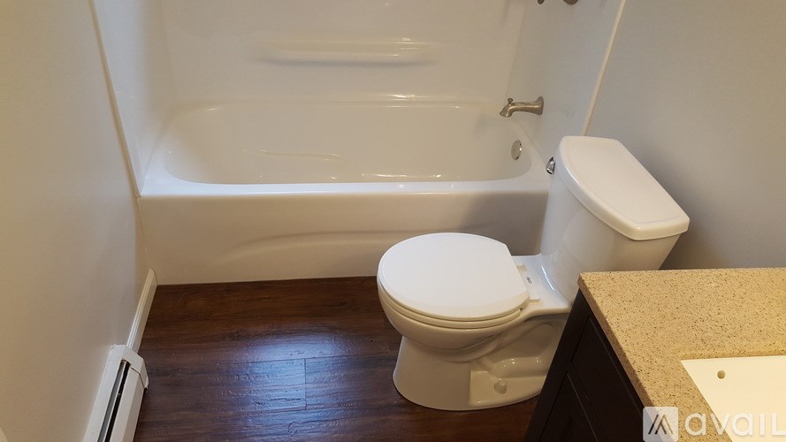 A white toilet sits next to a bathtub in a bathroom.
