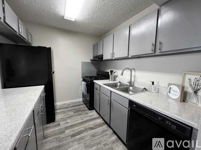 A kitchen with black appliances and white countertops.
