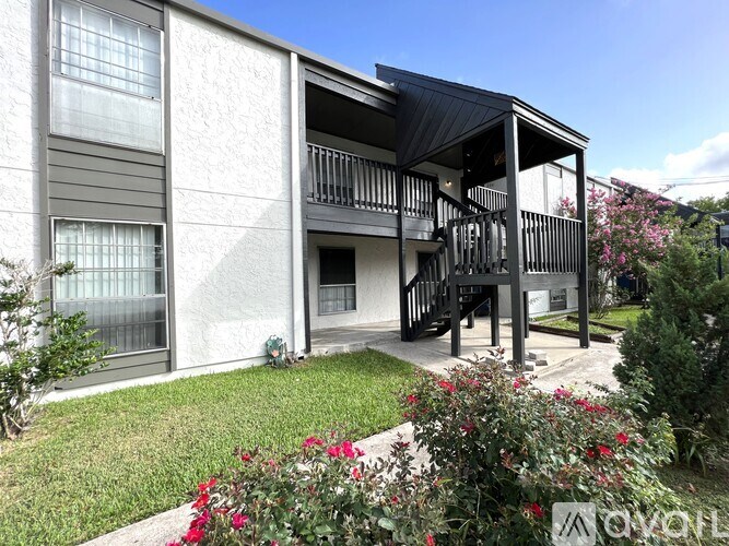 A modern house with a balcony and a garden in front.