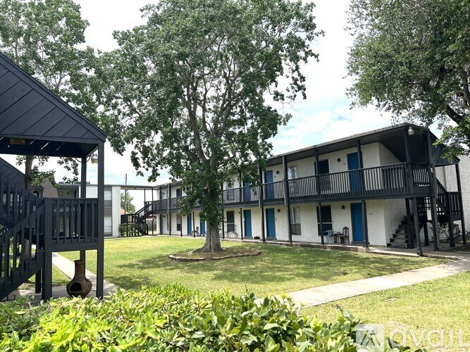 A building with a balcony and a tree in front of it.