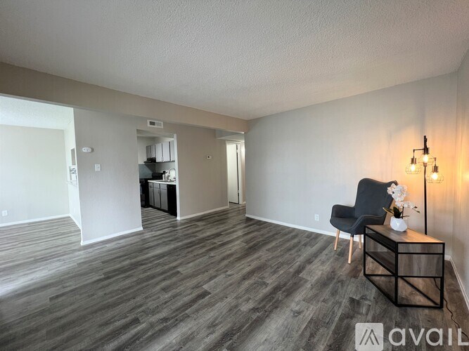A living room with a black chair and a wooden coffee table.